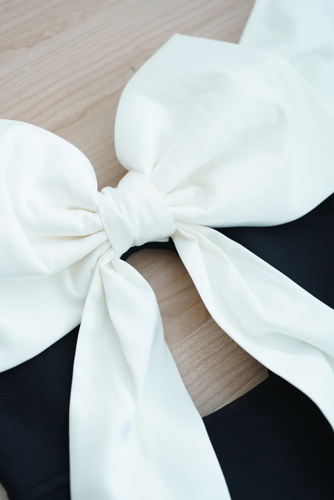 White bow fabric detail on black bandage maxi dress