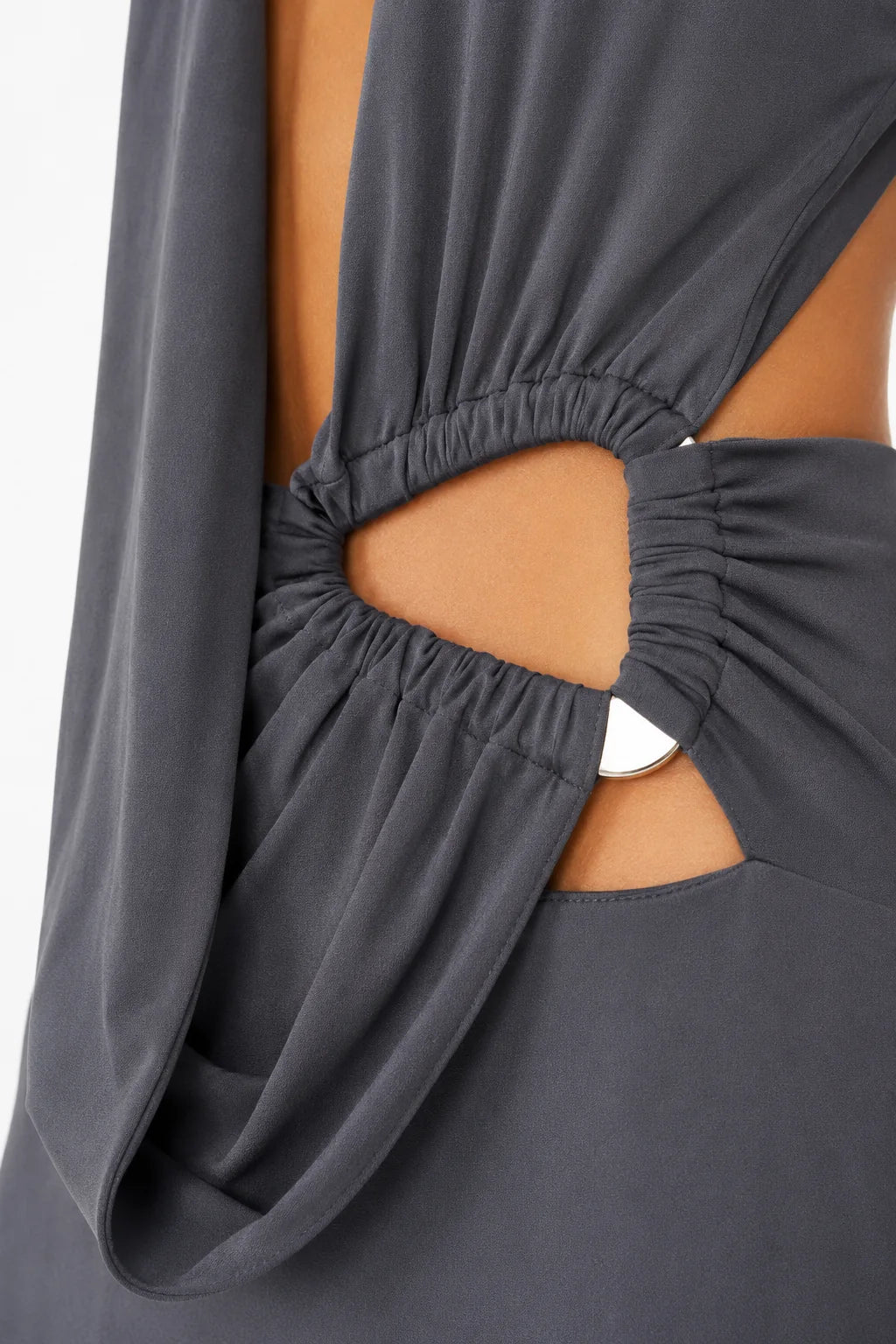 Close-up of ruched side cutout and metallic accent on charcoal gray maxi dress