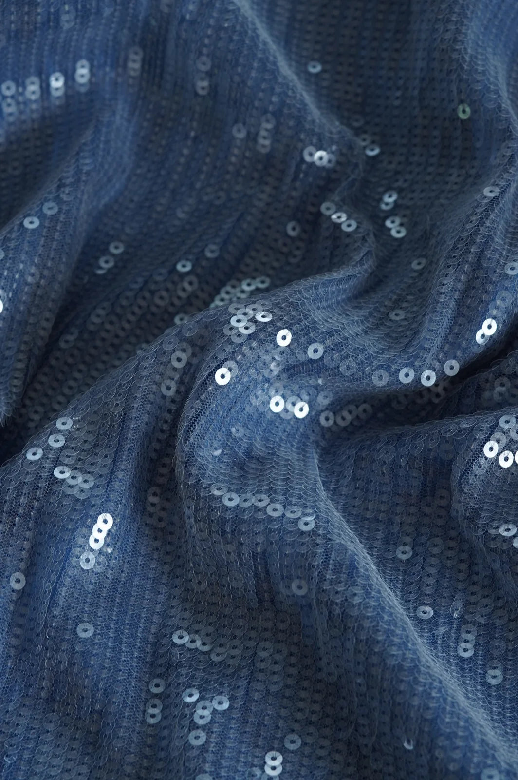 Close-up of light blue sequin fabric with silver sequins