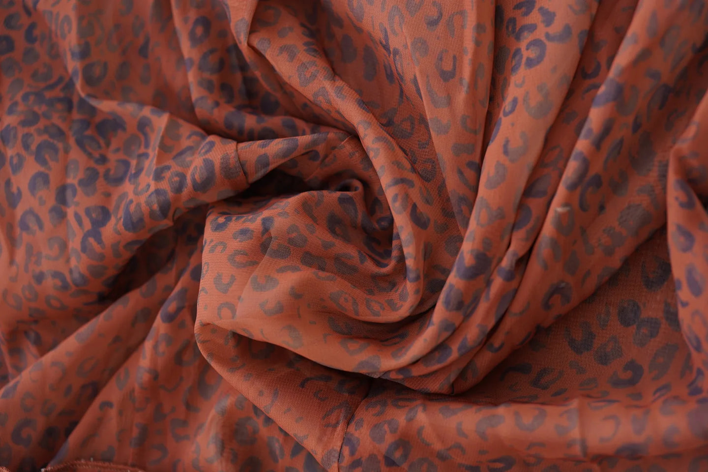 Close-up of rust leopard print mesh fabric